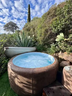 a large hot tub sitting in the grass at Maisonette les pieds dans l'eau in Pietrosella