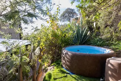 a large tub sitting in the middle of a garden at Maisonette les pieds dans l'eau in Pietrosella