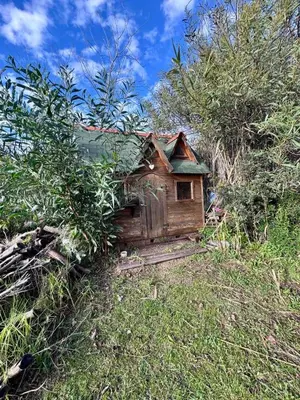 a small wooden house sitting in the grass at Maisonette les pieds dans l'eau in Pietrosella