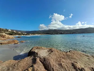 a view of a beach with rocks in the water at Maisonette les pieds dans l'eau in Pietrosella