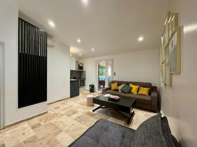 a living room with a couch and a table at Maisonette les pieds dans l'eau in Pietrosella