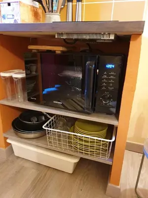 a microwave on a shelf in a kitchen at 10 min de Cortè, 5 couchages, in Venaco