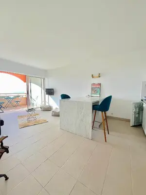 a living room with a table and chairs at Superbe Studio pieds dans l'eau - Parking gratuit - Terrasse - Emplacement idéal dans résidence de standing in Ajaccio