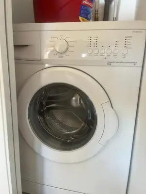 a white washer and dryer in a room at Superbe Studio pieds dans l'eau - Parking gratuit - Terrasse - Emplacement idéal dans résidence de standing in Ajaccio