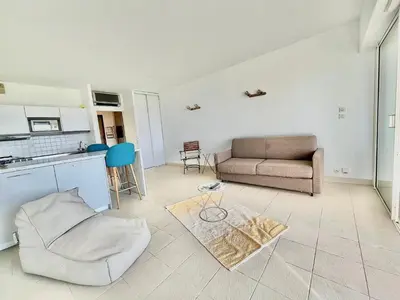 a living room with a couch and a table at Superbe Studio pieds dans l'eau - Parking gratuit - Terrasse - Emplacement idéal dans résidence de standing in Ajaccio