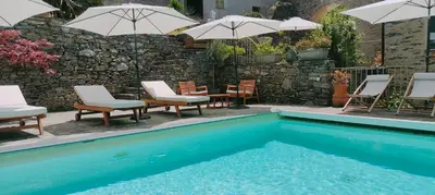 a pool with chairs and umbrellas and a group of tables and chairs at Stalla in Ortiporio
