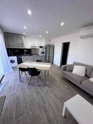 a living room with a table and a couch at U TERZU - Appart neuf spacieux in Aléria