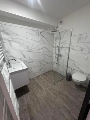 a bathroom with a shower and a sink and a toilet at U TERZU - Appart neuf spacieux in Aléria
