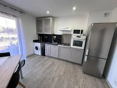 a kitchen with a stainless steel refrigerator and appliances at U TERZU - Appart neuf spacieux in Aléria