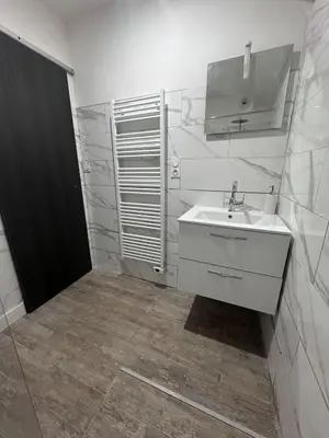 a white bathroom with a sink and a mirror at U TERZU - Appart neuf spacieux in Aléria