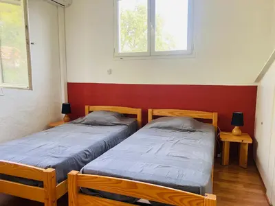two twin beds in a room with two windows at Villa Chérie 120m2 - Bord de Mer - Olmuccio 9 pers in Zonza