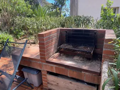 a brick barbecue grill on a wooden deck at Villa Chérie 120m2 - Bord de Mer - Olmuccio 9 pers in Zonza