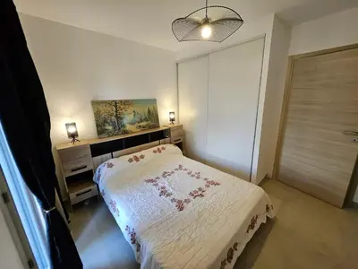 a small bedroom with a bed and a window at Appartement moderne à Lucciana avec terrasse ensoleillée. in Lucciana