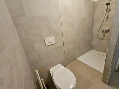 a small bathroom with a toilet and a shower at Appartement moderne à Lucciana avec terrasse ensoleillée. in Lucciana