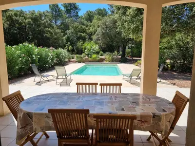 a patio with a table and chairs and a pool at Villa Stellalilou in Porto-Vecchio