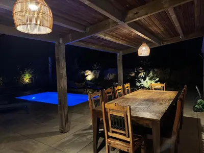 a wooden table and chairs on a patio with lights at A l'Ombra Di l'Alivu in Figari