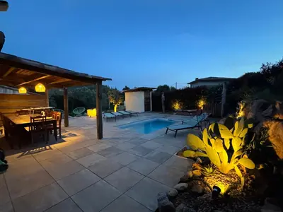 a patio with a swimming pool at night at A l'Ombra Di l'Alivu in Figari