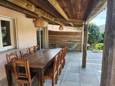 an outdoor dining room with a wooden table and chairs at A l'Ombra Di l'Alivu in Figari