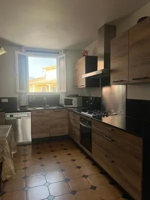 a kitchen with wooden cabinets and a window at Villa Santa Rita in Lucciana