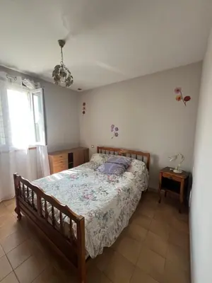 a bedroom with a bed and a lamp on a table at Villa Santa Rita in Lucciana