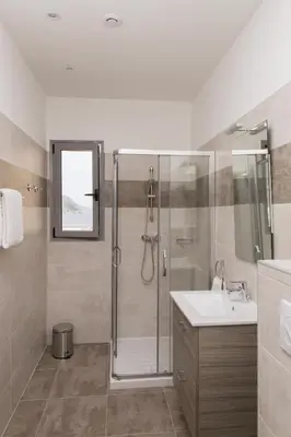 a bathroom with a shower and a sink at Résidence Hotelière Capu Seninu in Porto Ota