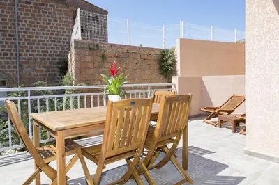 a wooden table and chairs on a patio at Résidence Hotelière Capu Seninu in Porto Ota