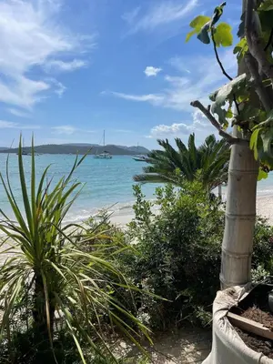 a view of the beach with a boat in the water at Villa La Vesta Porto Vecchio in Porto-Vecchio