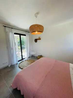 a bedroom with a pink bed and a large window at Villa La Vesta Porto Vecchio in Porto-Vecchio