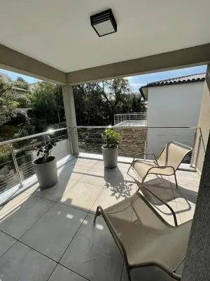 a patio with two chairs and two plants on it at Villa La Vesta Porto Vecchio in Porto-Vecchio