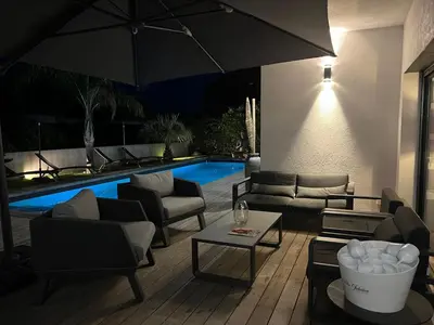 a patio with furniture and a swimming pool at night at Villa 