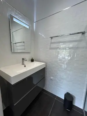 a white bathroom with a sink and a mirror at Villa 