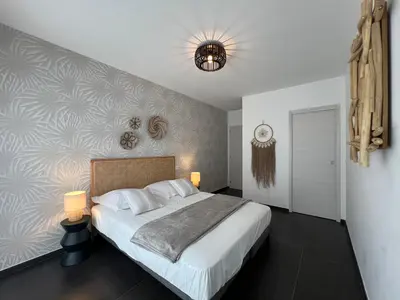 a bedroom with a large bed and a wall at Villa 