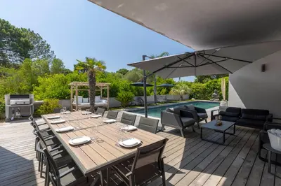 a wooden deck with a table with chairs and an umbrella at Villa 