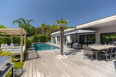 a patio with a table and chairs and a swimming pool at Villa 