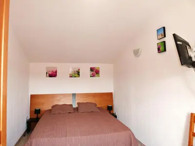 a bedroom with a bed and paintings on the wall at Villa bord de mer,3 chambres, piscine chauffée, climatisée in Cervione