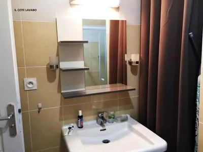 a bathroom with a sink and a mirror at Villa bord de mer,3 chambres, piscine chauffée, climatisée in Cervione