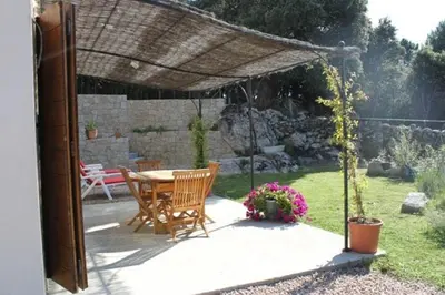 a patio with a table and chairs under a pergola at Quenza-Alta Rocca in Quenza