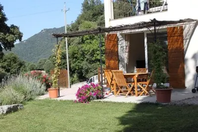 a house with a table and chairs in a yard at Quenza-Alta Rocca in Quenza