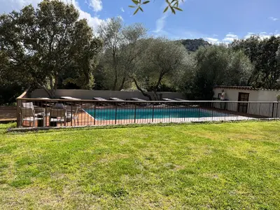 a fence around a swimming pool in a yard at Les Bergeries de Petralonga in Sotta