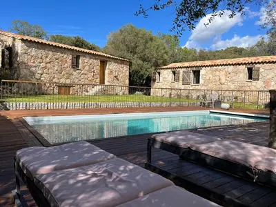 a swimming pool in front of a stone building at Les Bergeries de Petralonga in Sotta