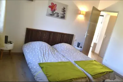 a bedroom with a bed with a green pillow on it at Les Bergeries de Petralonga in Sotta