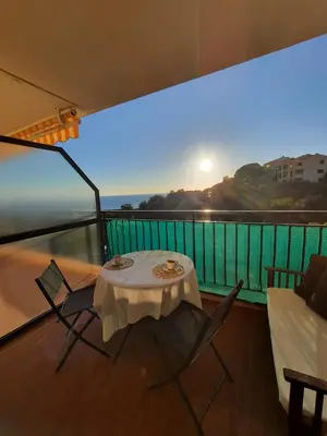 a table and chairs on a balcony with a view at Studio vue mer Sanguinaires 3 minutes des plages in Ajaccio