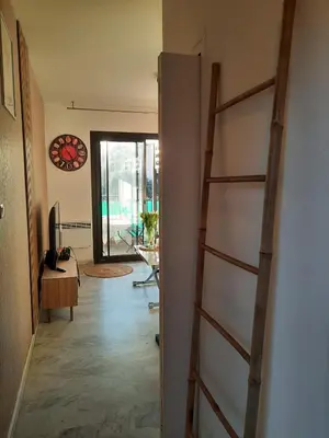 a hallway with a ladder leading to a living room at Studio vue mer Sanguinaires 3 minutes des plages in Ajaccio