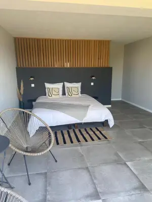 a bedroom with a large bed and a chair at Santa Giulia Camara - Lecci Lodge in Lecci