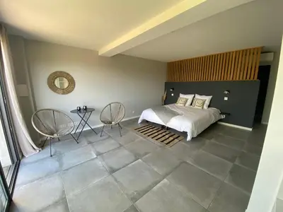 a bedroom with a bed and two chairs at Santa Giulia Camara - Lecci Lodge in Lecci