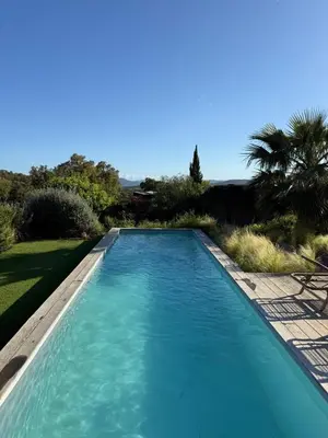 a large blue swimming pool in a yard at Santa Giulia Camara - Lecci Lodge in Lecci