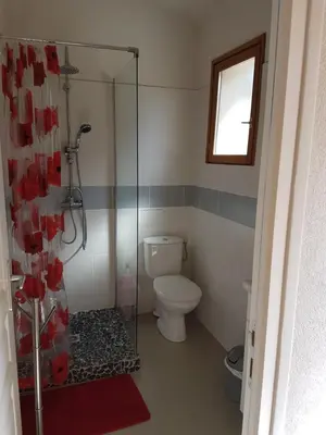 a bathroom with a toilet and a glass shower stall at Studio pour 2 personnes à 700m de la plage de palombaggia in Porto-Vecchio