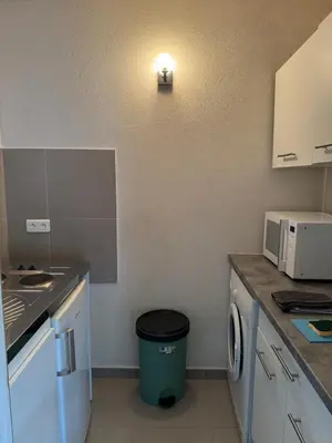 a small kitchen with a trash can in the corner at Studio pour 2 personnes à 700m de la plage de palombaggia in Porto-Vecchio