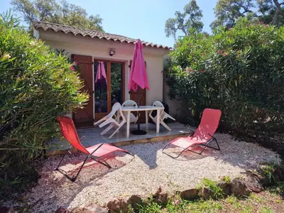 a patio with a table and chairs and an umbrella at Studio pour 2 personnes à 700m de la plage de palombaggia in Porto-Vecchio