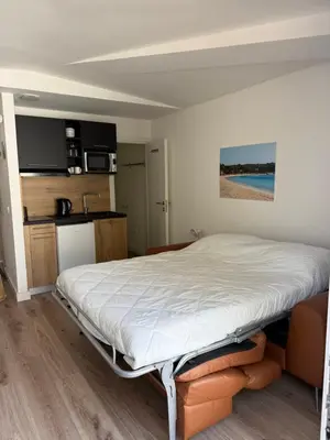 a bed in a room with a kitchen at Studio 47 Cala Rossa Porto Vecchio in Lecci
